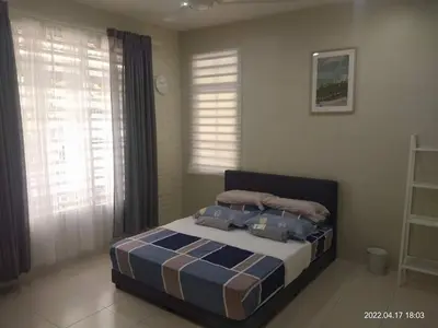 a bedroom with a bed in a room with windows at Park Villa Homestay in Sungai Petani