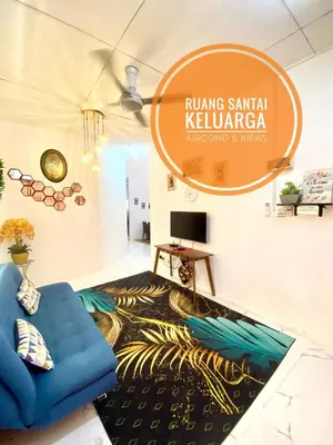 a living room with a blue couch and a rug at LH Homestay Bandar Utama Gua Musang in Gua Musang