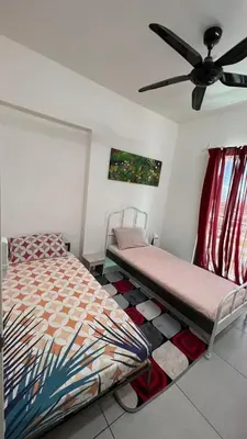 a bedroom with two beds and a ceiling fan at D Naurah Meritus Guesthouse in Perai