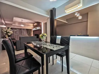 a dining room with a black table and chairs at Ipoh Town Kinta Riverfront Apartment 7pax by Glamorous in Ipoh