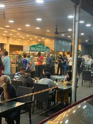 a group of people sitting at tables in a restaurant at NEW 6 PAX SUITE near USM and SPICE ARENA and AIRPORT in Bayan Lepas
