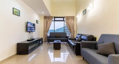 a living room with two couches and a flat screen tv at Batu Ferringhi Sea View Penthouse Resort Home in Bayan Lepas