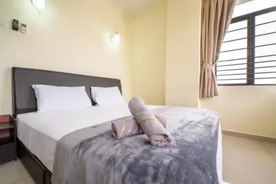 a bedroom with a bed with a stuffed animal on it at Batu Ferringhi Sea View Penthouse Resort Home in Bayan Lepas