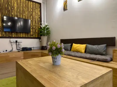 a living room with a vase of flowers on a table at Ipoh Family Masjid Muhammadiah Evicharger SY15 in Ipoh