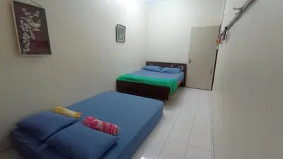 a room with two beds and a couch in it at HEAWOOD GUEST HOUSE Sungai Siput in Sungai Siput