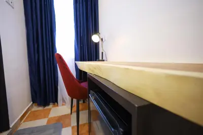 a room with a counter and a red chair at RENTIO HOTEL in Kulim