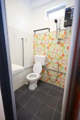 a bathroom with a toilet and a shower at RENTIO HOTEL in Kulim
