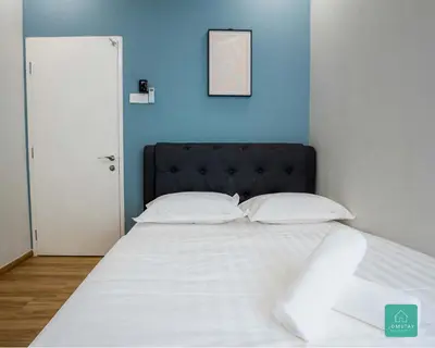 a bed with a black headboard and white sheets and pillows at Jomstay The Cove Ipoh Hillside Residence in Ipoh