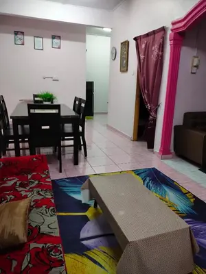 a living room with a table and a couch at Rizki Homestay in Nibung Tebal