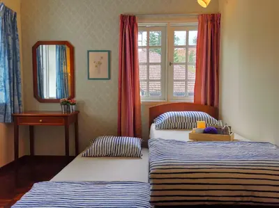 a bedroom with two beds and a mirror and a window at Green Hill Apartment in Tanah Rata