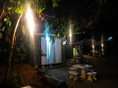 a picnic table in front of a house at night at Tanah Merah Glamping Village (TMGV) in Kuala Kangsar