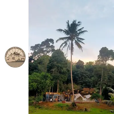 a palm tree in front of a house at Tanah Merah Glamping Village (TMGV) in Kuala Kangsar