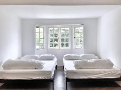 two beds in a room with two windows at 80 Colonie Fraser's Hill 4pax in Bukit Fraser