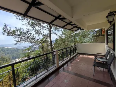 a balcony with chairs and a view of the mountains at Awesome Homestay Apartment @ Equatorial Hill Resort in Brinchang