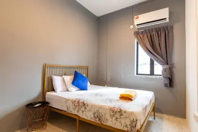 a bedroom with a bed with blue pillows and a window at Mac Inn 94 in George Town