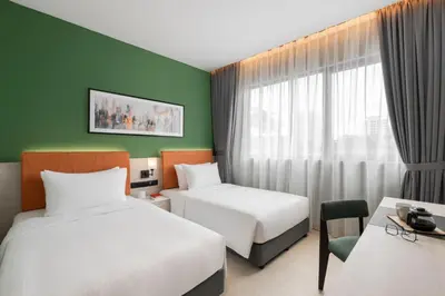 a hotel room with two beds and a window at Citadines Connect Georgetown Penang in George Town