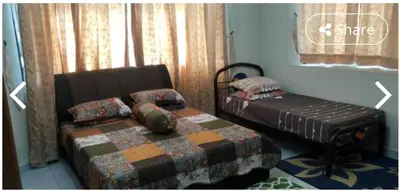 a bedroom with a bed and a ottoman next to a window at LOST WORLD OF TAMBUN HOMESTAY in Kampong Batu Lapan