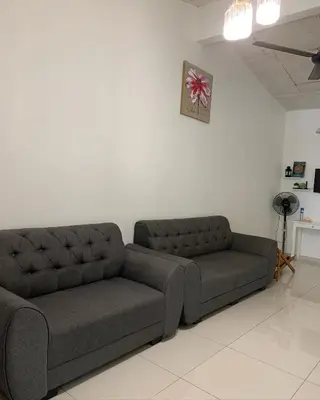 a couch sitting in a living room next to a wall at Jasmine Homestay Meru Ipoh in Ipoh
