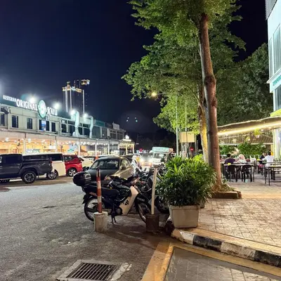 a motorcycle parked on the side of a street at night at 6 PAX 1 BEDROOM SOHO near SPICE ARENA PANTAI SPECIALIST AIRPORT in Bayan Lepas
