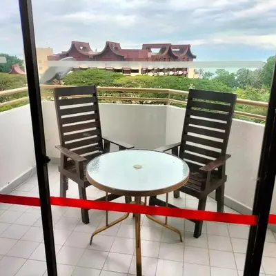 two chairs and a table on a balcony at Batu Feringgi Sri Sayang Apartment in Batu Ferringhi