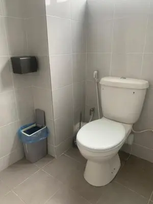 a bathroom with a white toilet and a trash can at \u4f11\u95f2\u6c11\u5bbf Leisure Homestay @The Venus Sitiawan in Kampong Lumut Kiri