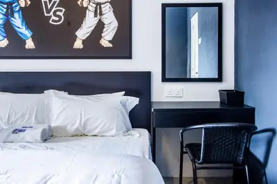 a bedroom with a bed and a chair in it at CITY HUNTER At Georgetown in George Town
