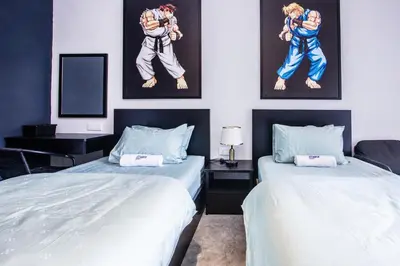 two beds in a room with paintings on the wall at CITY HUNTER At Georgetown in George Town