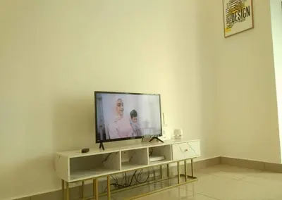 a television sitting on a stand in a living room at Armada Sweet Homestay in Gua Musang