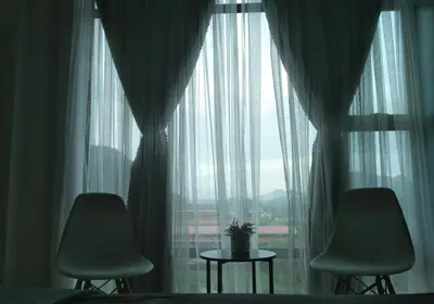 a bedroom with two chairs and a large window at Armada Sweet Homestay in Gua Musang