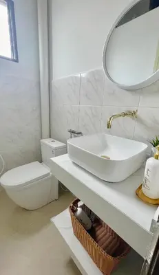 a white bathroom with a sink and a toilet at Helena’s Studio Suite Gerik in Gerik