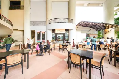 a group of people sitting at tables in a restaurant at Rainbow paradise at Tanjung Bungah in Tanjung Bungah