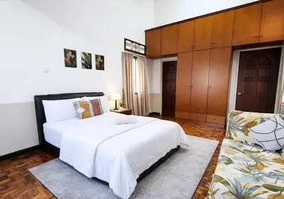 a bedroom with a large white bed and a couch at Advent Villa, just 80 meters to Penang Adventist Hospital in George Town