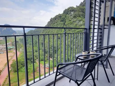 a balcony with chairs and a view of a mountain at Sunway Onsen Studio @ Lost World of Tambun in Ipoh