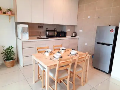 a kitchen with a wooden table with chairs and a refrigerator at Sunway Onsen Studio @ Lost World of Tambun in Ipoh