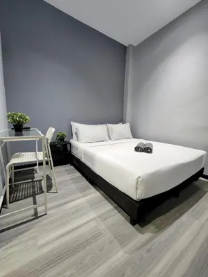 a bedroom with a bed and a table and a chair at Gurney Coast Guest House by Sky Hive in George Town