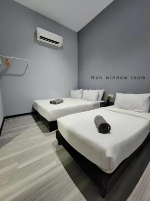 a room with two beds and a sign on the wall at Gurney Coast Guest House by Sky Hive in George Town
