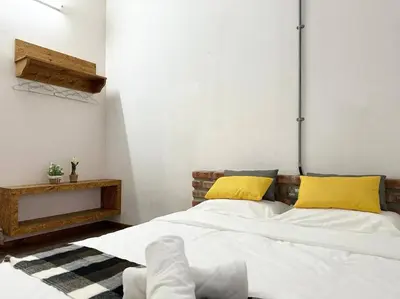 a bedroom with a large white bed with yellow pillows at Ipoh Family Homestay Masjid Muhammadiah Evicharger SY16 in Ipoh