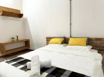 a bedroom with two beds with white sheets and yellow pillows at Ipoh Family Homestay Masjid Muhammadiah Evicharger SY16 in Ipoh