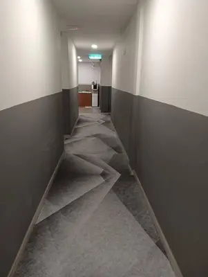 an empty hallway with gray and white walls at The Great Hotel in Ipoh