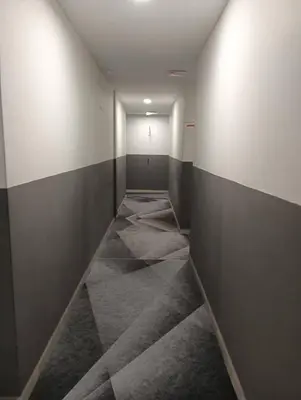 an empty hallway with a room with gray and white walls at The Great Hotel in Ipoh