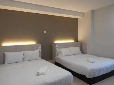 two beds with white pillows in a room at The Great Hotel in Ipoh