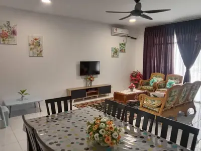 a living room with a dining table and a television at AWANA HOMESTAY in Sungai Petani