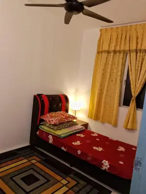 a bedroom with a red bed with a ceiling fan at AWANA HOMESTAY in Sungai Petani