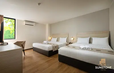 a hotel room with two beds and a television at Sunstone Hotel in George Town