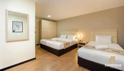 a hotel room with two beds and a mirror at Sunstone Hotel in George Town