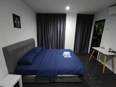 a bedroom with a blue bed and a table at 184 GURNEY DRIVE PENANG in George Town