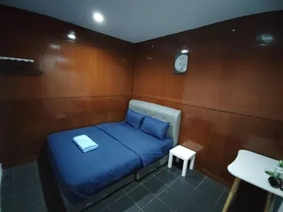 a small room with a blue bed and a table at 184 GURNEY DRIVE PENANG in George Town