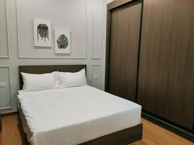 a bedroom with a white bed and a wooden cabinet at Beacon Executive Suites 2BR at Georgetown by WL in George Town
