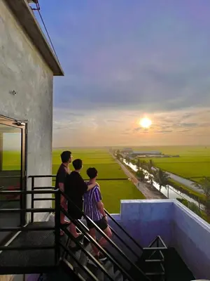 three people standing on a balcony looking at the sunset at PADI Sentral @ Sekinchan in Sekincan