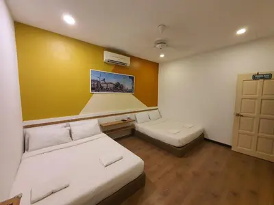 a room with two beds and a yellow wall at Landed Home near Gurney and Georgetown for 18pax WL in George Town